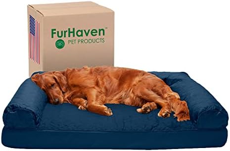 A golden retriever is sleeping on a large, dark blue dog bed. Behind the bed is a cardboard box labeled FurHaven Pet Products with an American flag printed on it.